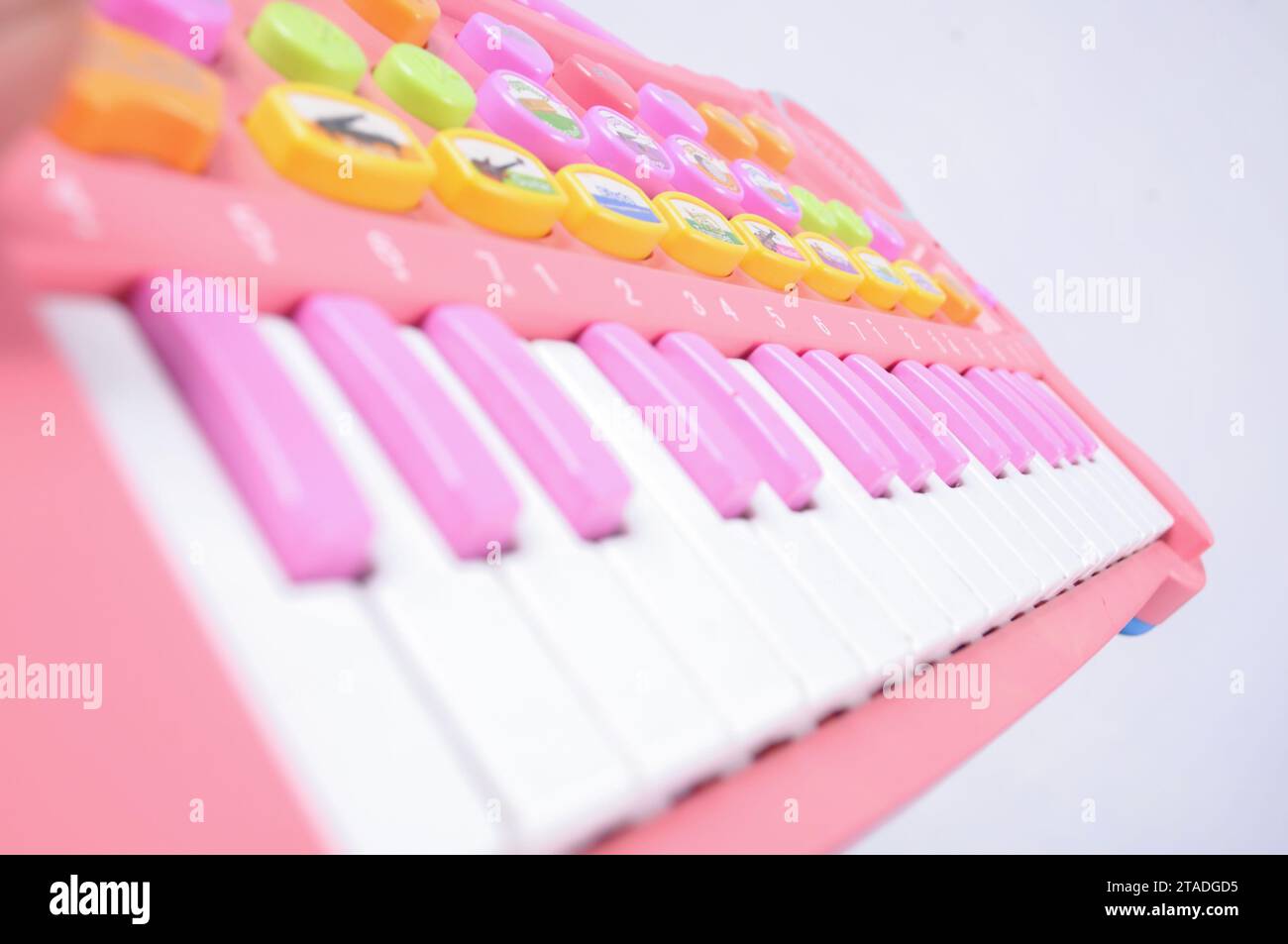 A close-up view of a pink children s toy piano with neatly lined keys and an isolated background Stock Photo
