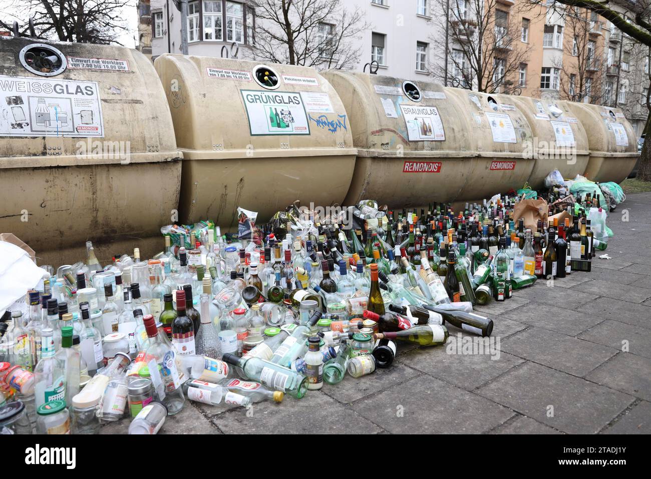 Overflowing recycling glass bottle containers with rows of bottles