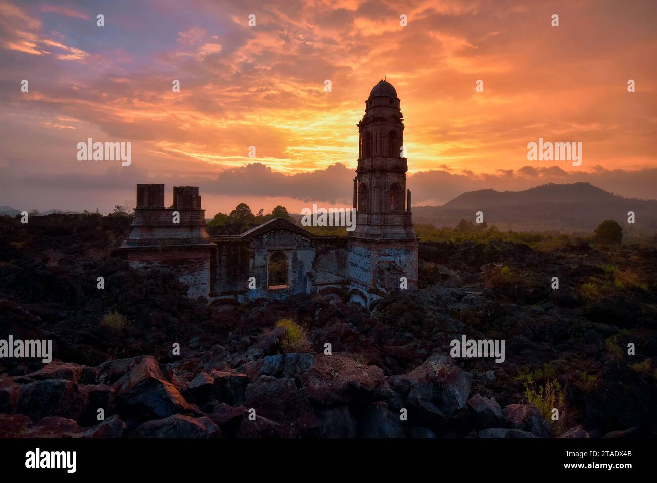 A Sunset at the ruins of the temple of San Juan Parangaricutiro, destroyed by the eruption of the Paricutin Volcano, Mexico Stock Photo