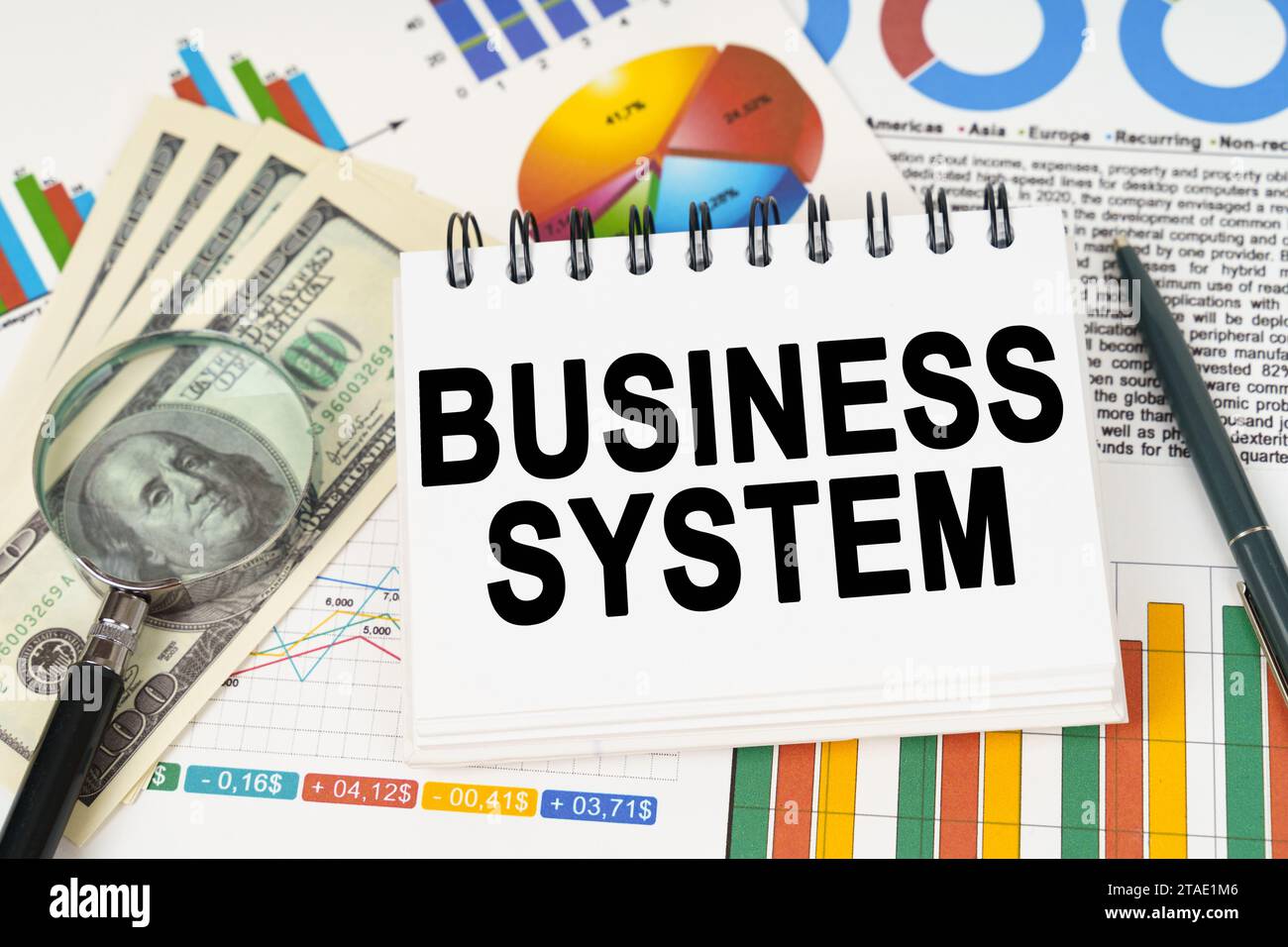 Business concept. On the table are business charts, dollars and a notepad with the inscription - Business System Stock Photo