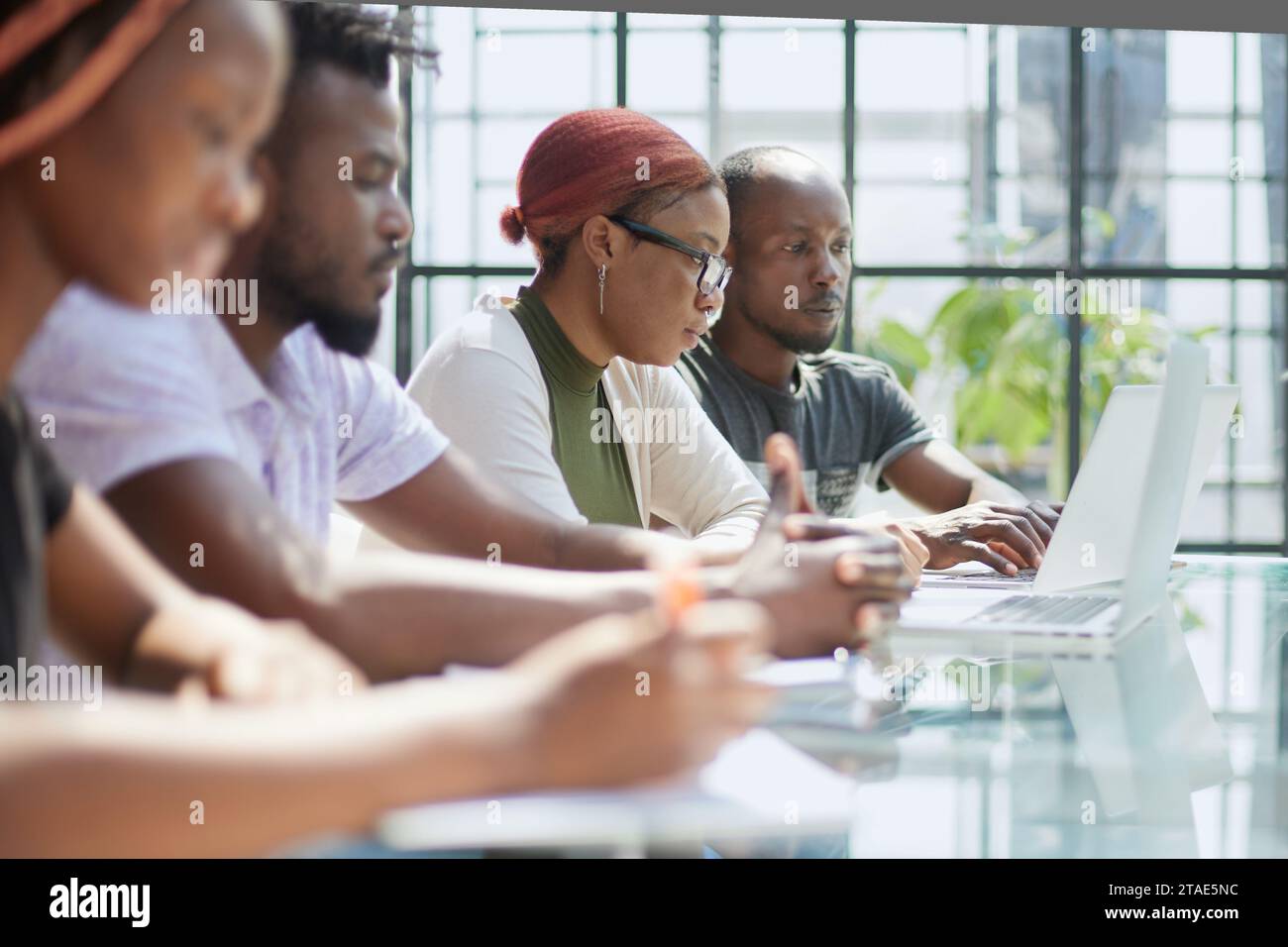 Employees working at computer together, discussing content. Stock Photo