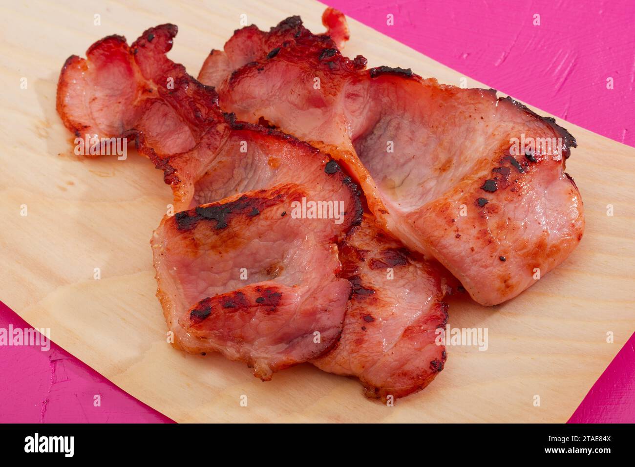 Two rashers of bacon just out of the frying pan. Stock Photo