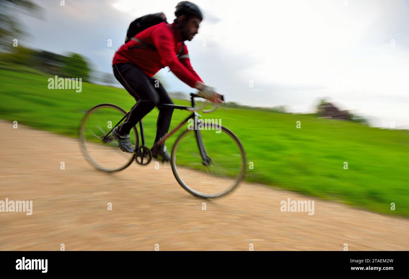 Image Cycle A man cycles along one of the gravel paths in Hampstead Heath in North ...