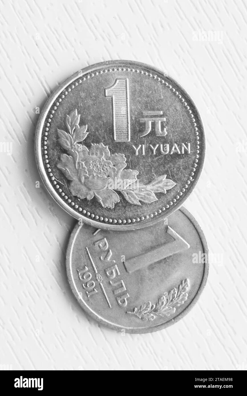 Vertical photo of one Russian ruble and one Chinese yuan on a white ...