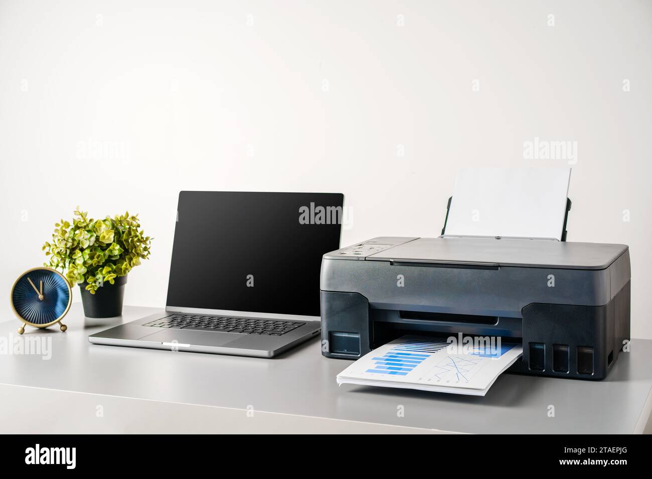 Printer and laptop on grey table in office Stock Photo