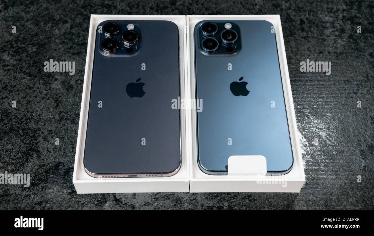 Jurmala, Latvia - 30 11 2023: Open box with new iPhone 15 Blue Titanium and open box with previous iPhone 14 Pro Max in Deep Purple on grey table. Stock Photo