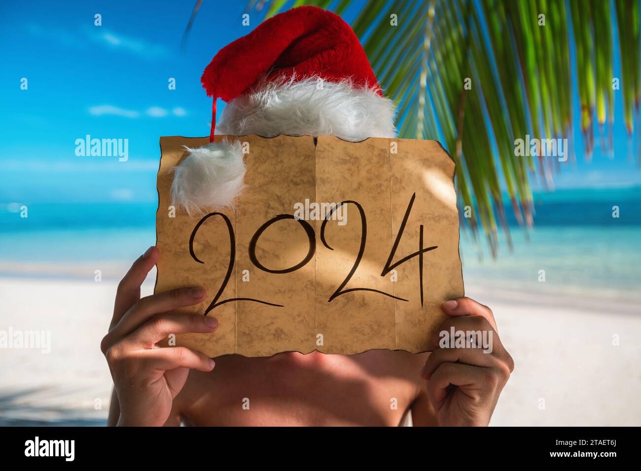 2024 Happy New Year .Tourist man with Santa Claus hat relaxing on tropical island beach. Punta Cana, Dominican Republic. Stock Photo