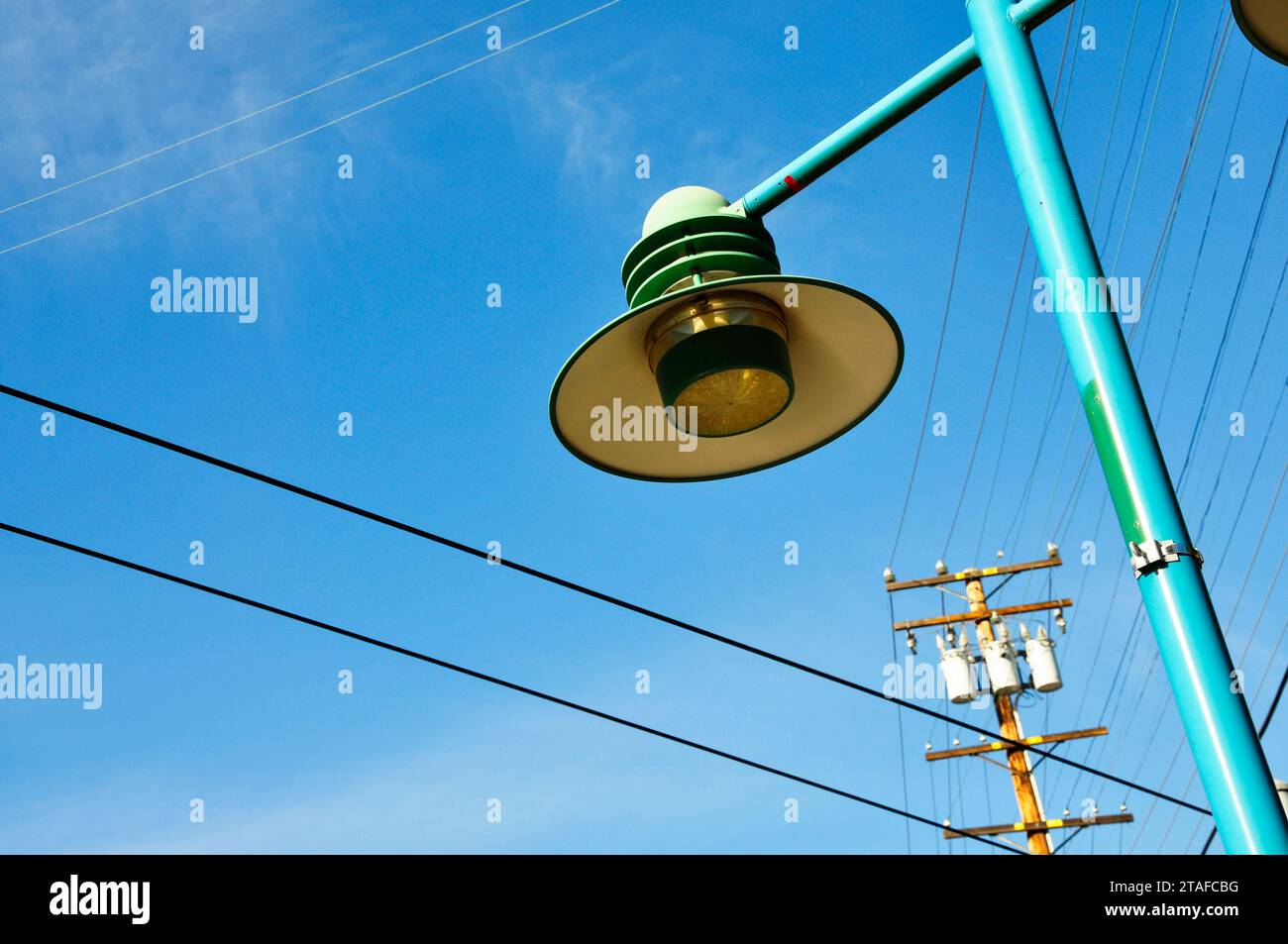 A vintage Los Angeles streetlight is seen with a power transformer in the background. Concept of wildfires and the grid. Stock Photo