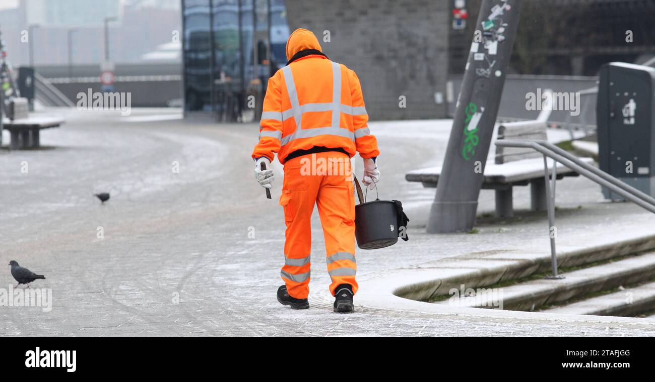 Ein Mitarbeiter der Hamburger Stadtreinigung, der für das Streuen der Wege  zuständig ist, geht bei eisiger Kälte mit einem Eimer mit Streusalz die  Jan-Fedder-Promenade entlang. Altstadt Hamburg *** An employee of the