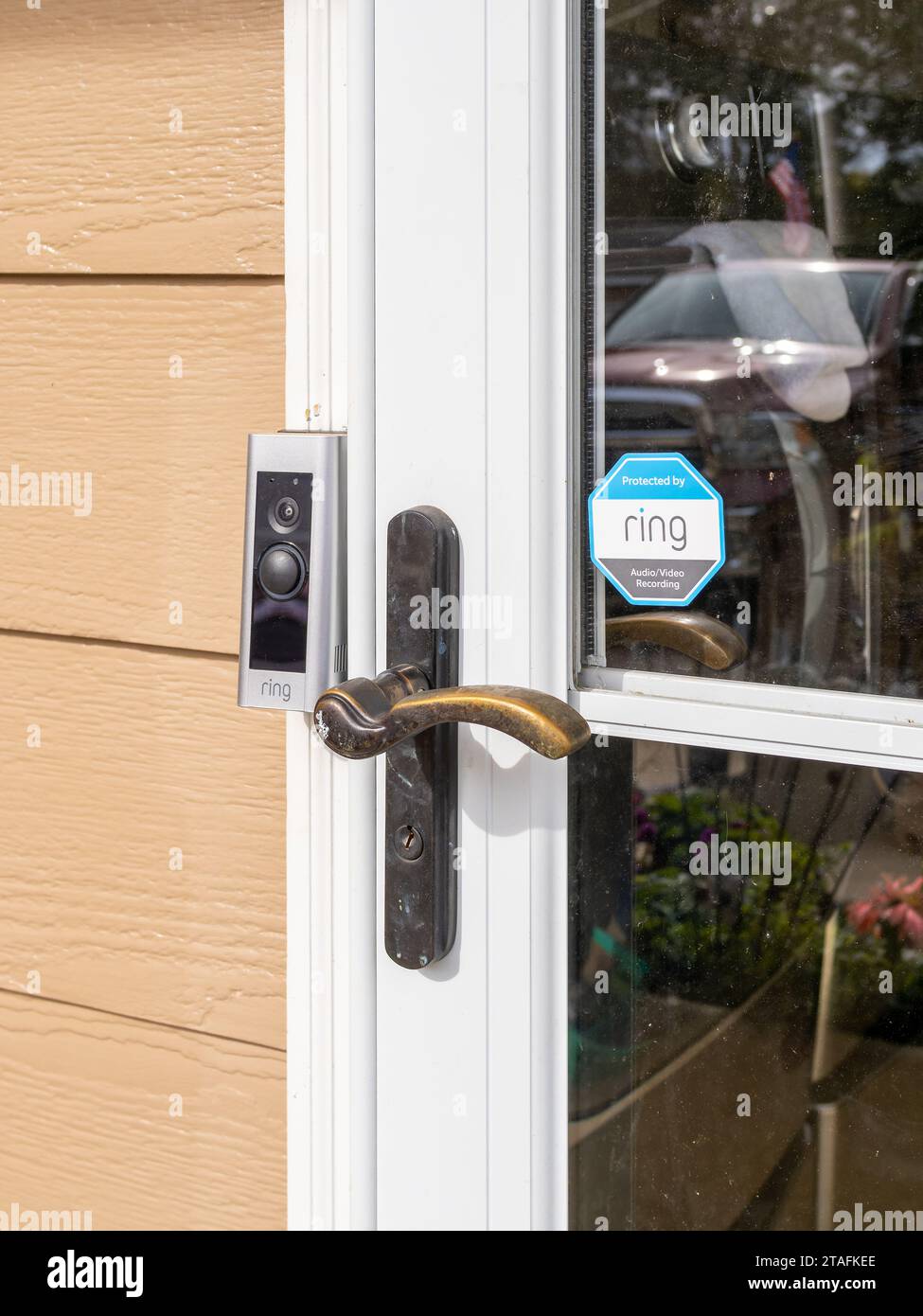 Ring doorbell surveillance camera, at the front door of a residence, house or home with a logo warning sticker on the door in Alabama, USA. Stock Photo