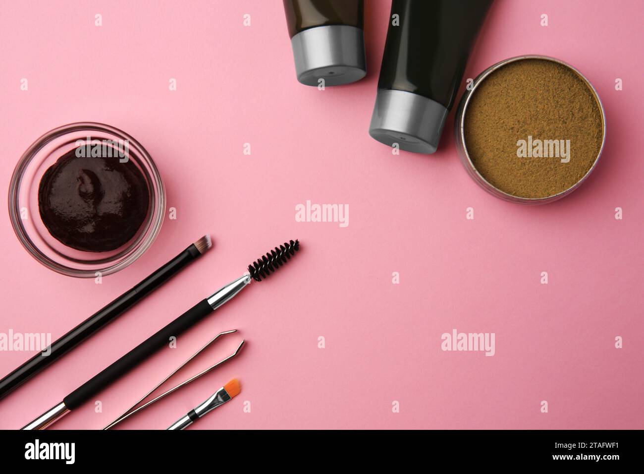 Flat lay composition with eyebrow henna and tools on pink background. Space for text Stock Photo