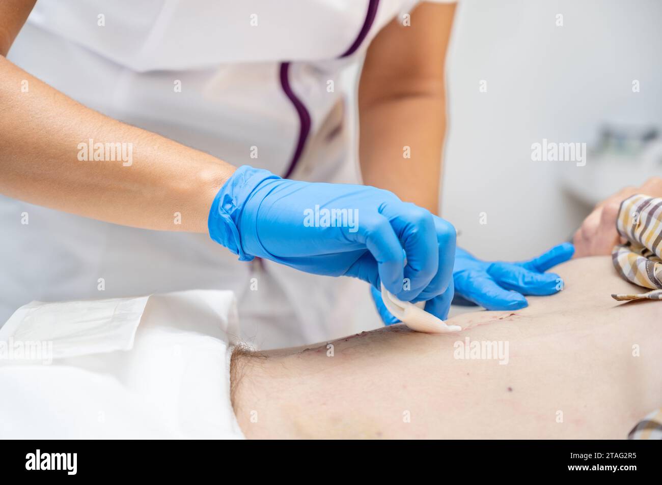 hand of Doctor is using clean cotton dressing infection wound at a man