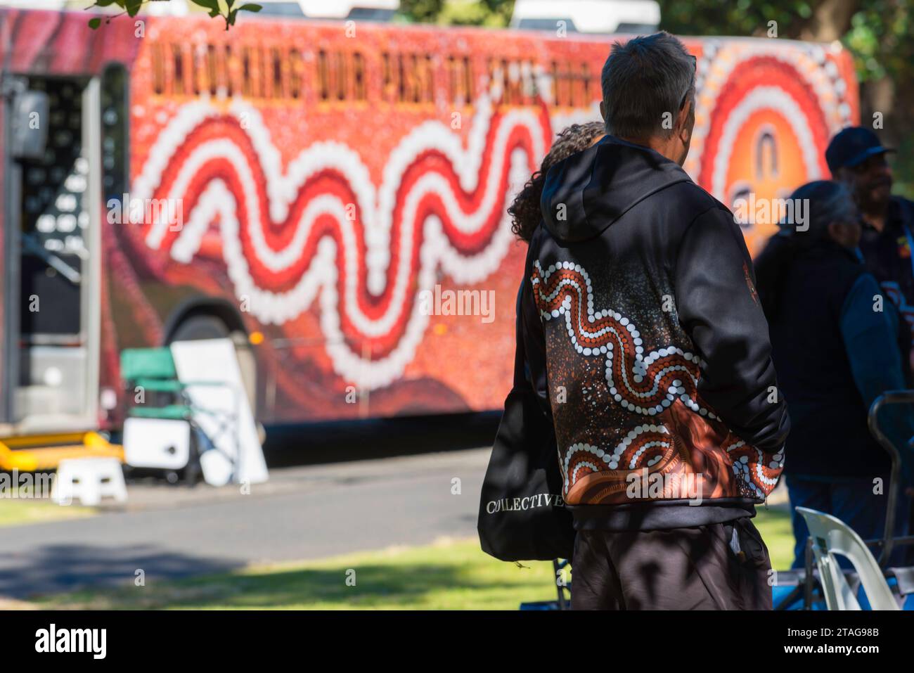 First Nations indigenous Aboriginal man wearing a Kinchela art design jacket at the Sorry Day event in Sydney during National Reconciliation Week Stock Photo