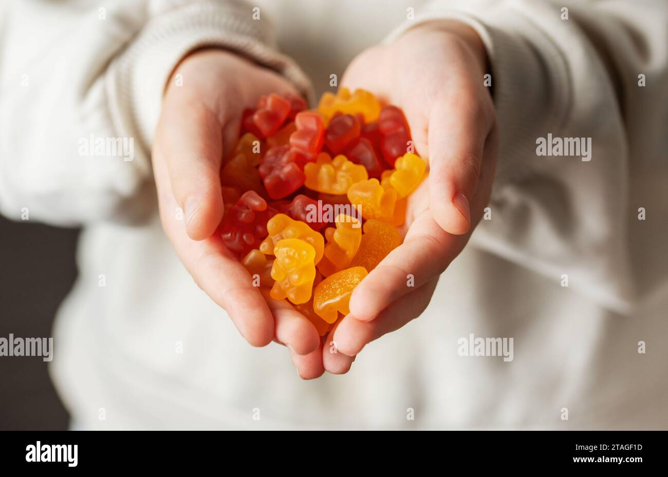 Chewable gummy bears vitamins and supplements.  A girl holds a gummy bear vitamines in her hands. Stock Photo