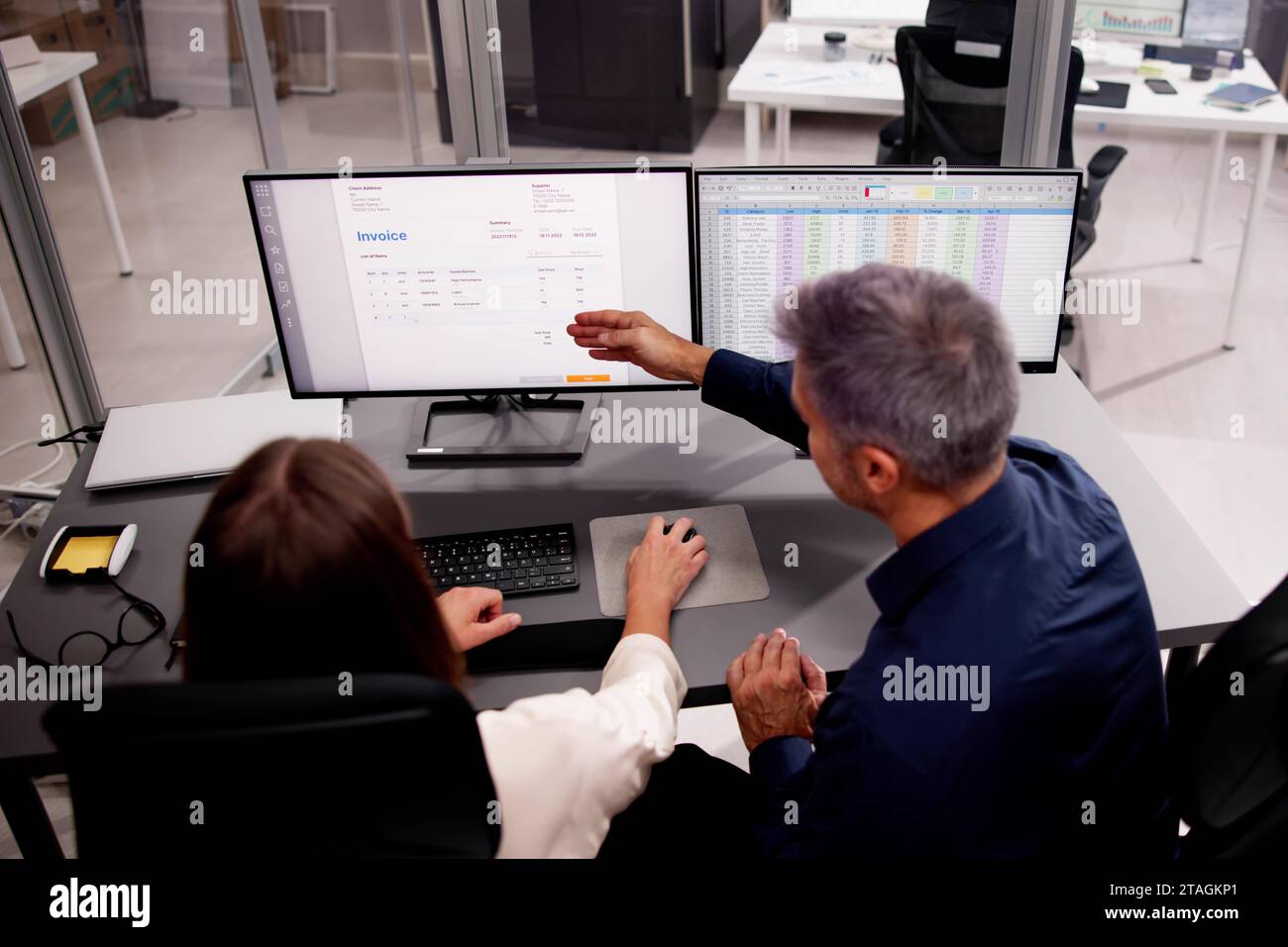 Working Analyst at Desktop PC with Multiple Spreadsheets Stock Photo