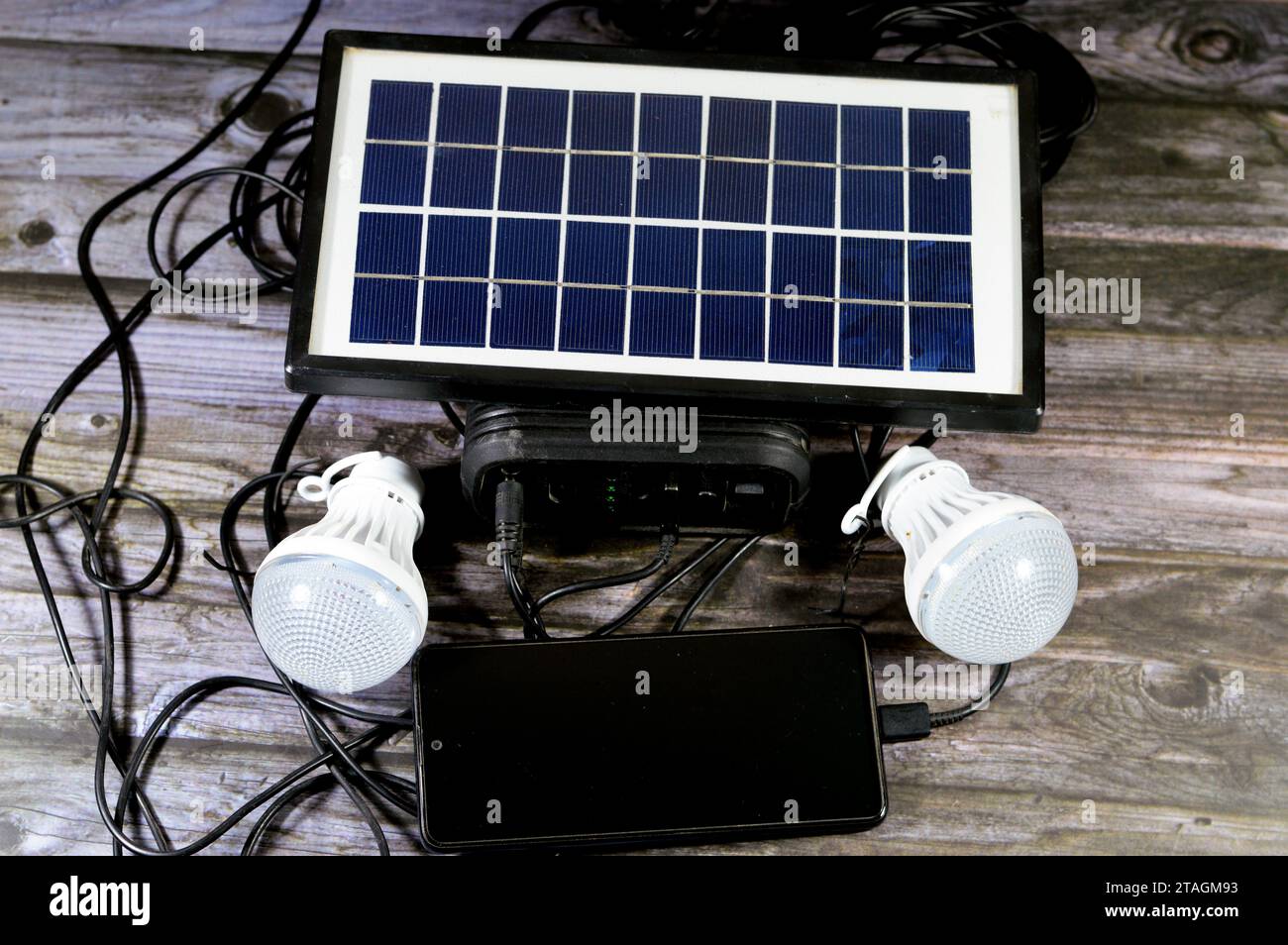 A multi purpose battery charged with a solar panel, a device that converts sunlight into electricity by using photovoltaic (PV) cells, with charging c Stock Photo