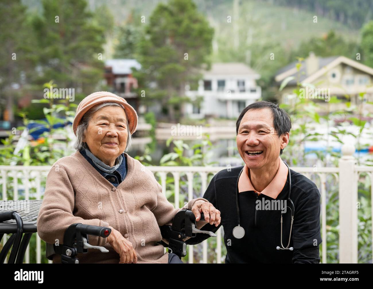 Male Doctor visiting senior patient at home. Patient sitting on the mobility walker in the backyard. Stock Photo