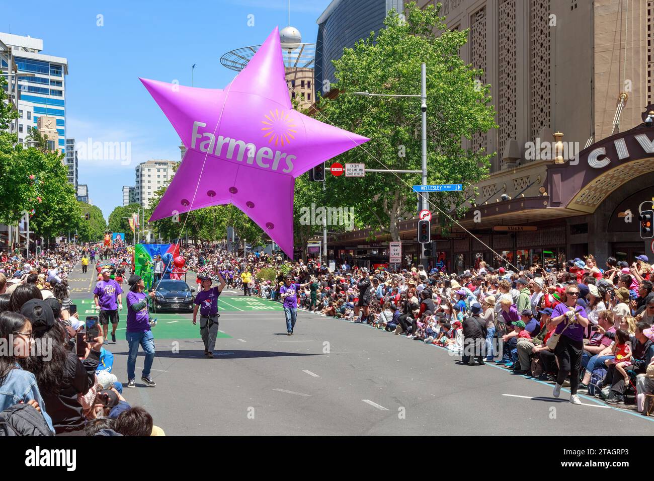 The Farmers Christmas Parade in Auckland, New Zealand. The Farmers department store logo on a star-shaped balloon pulled by volunteers Stock Photo