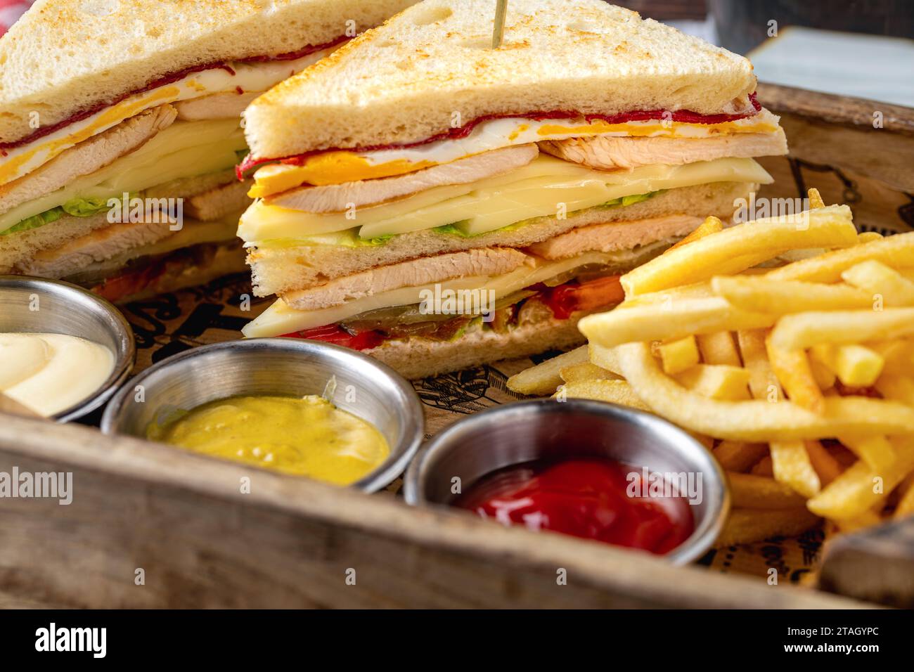 Chicken club sandwich with fries, ketchup, mustard and mayonnaise Stock