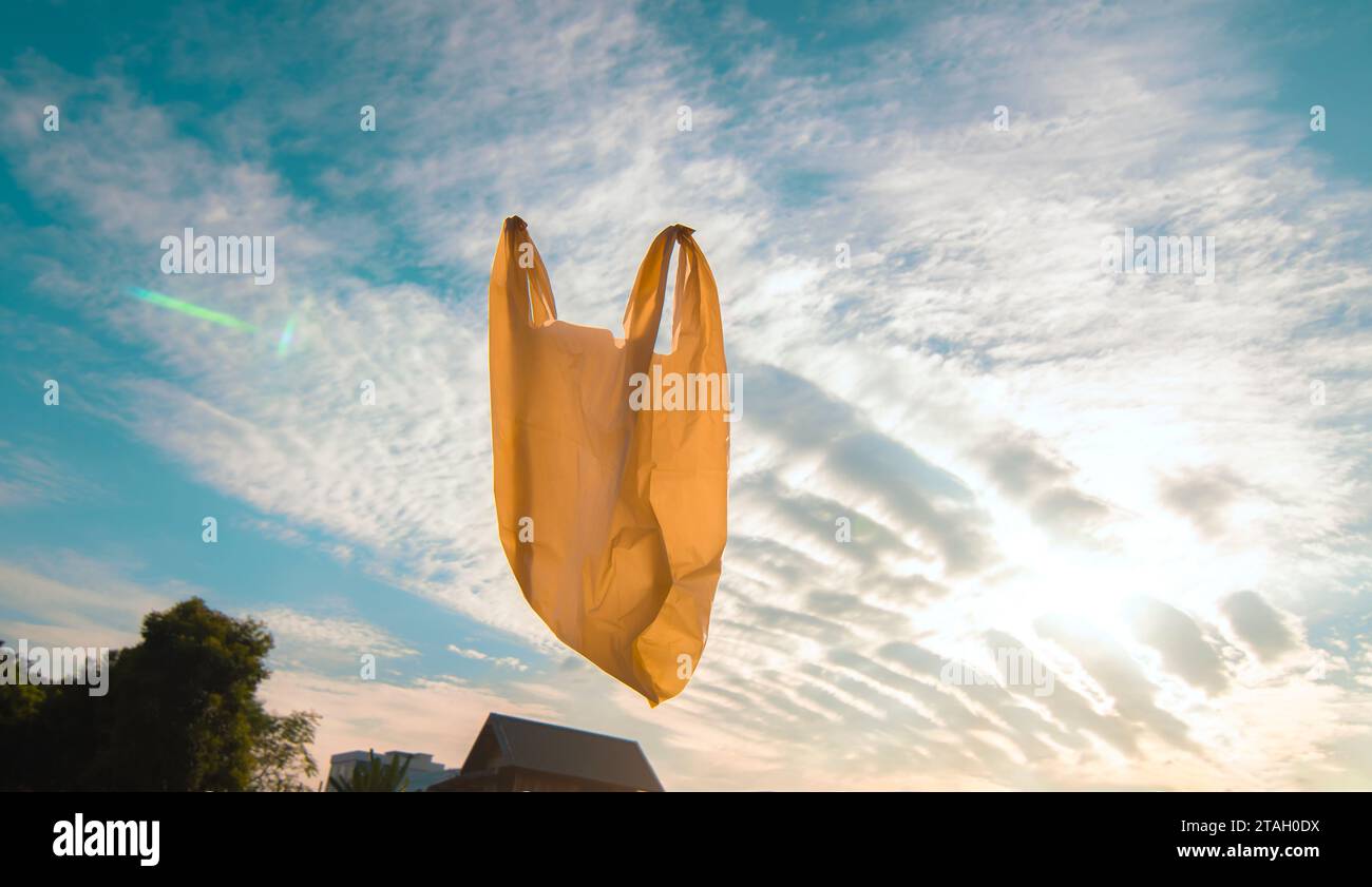 Used plastic bags floating in the air and garden, garbage and pollution, global warming and climate change. Stock Photo