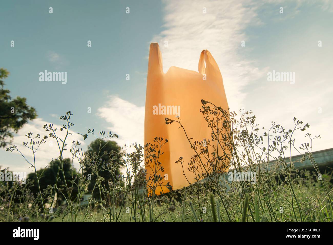 Used plastic bags floating in the air and garden, garbage and pollution