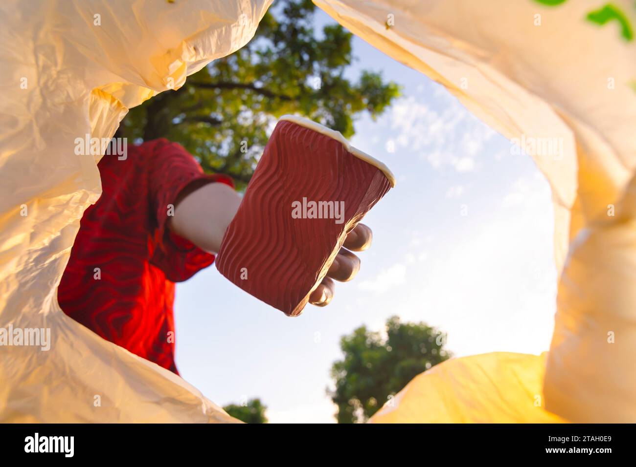 Volunteers put coffee cup waste into plastic bags for recycling, Reuse, and waste management concepts. Stock Photo