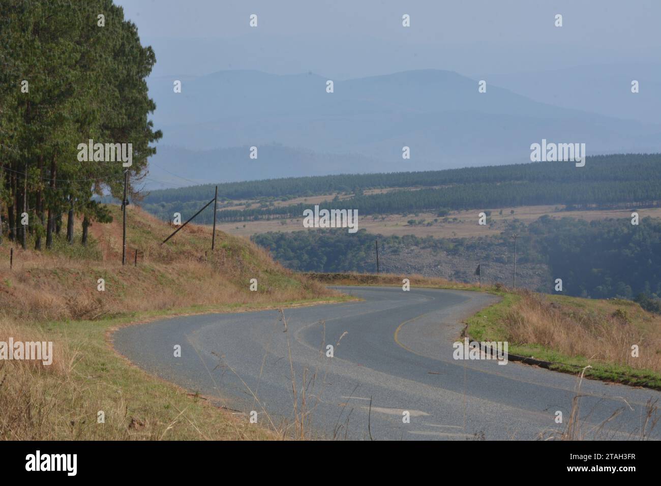Road over farm lands in South Africa towards distant mountains Road over farm lands in South Africa towards distant mountains Stock Photo