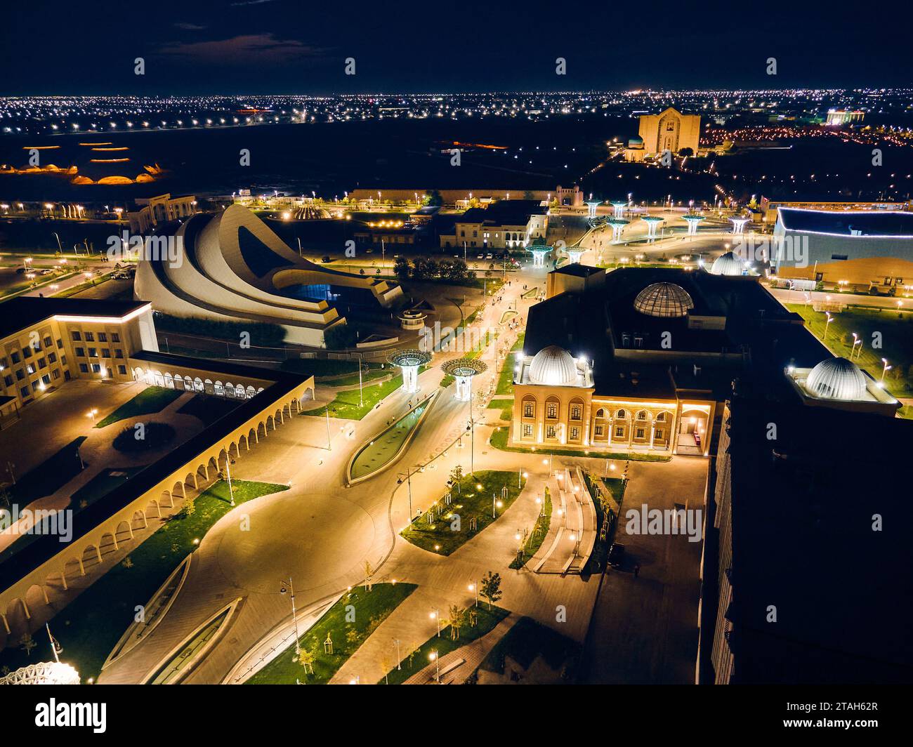Aerial drone shot of central street of Caravan Sarai in Turkestan at night illuminated streets. Modern eastern architecture in South Kazakhstan Stock Photo