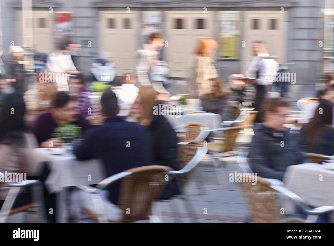 Motion effect in photography. Slow time exposure. Outdoor restaurant. People Stock Photo