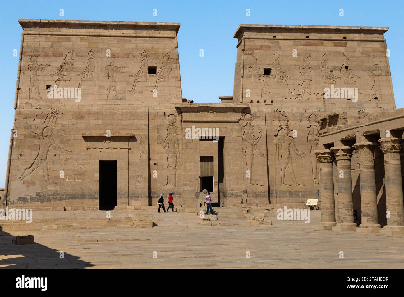Tourists exploring the Philae Temple under a blue sky Stock Photo