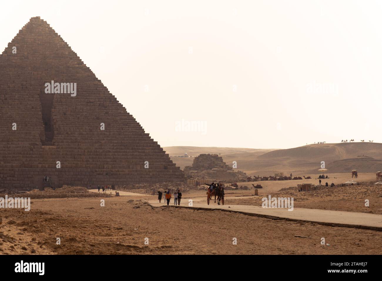 Tourists visiting the Gyza Pyramids during sunny day, Egypt Stock Photo