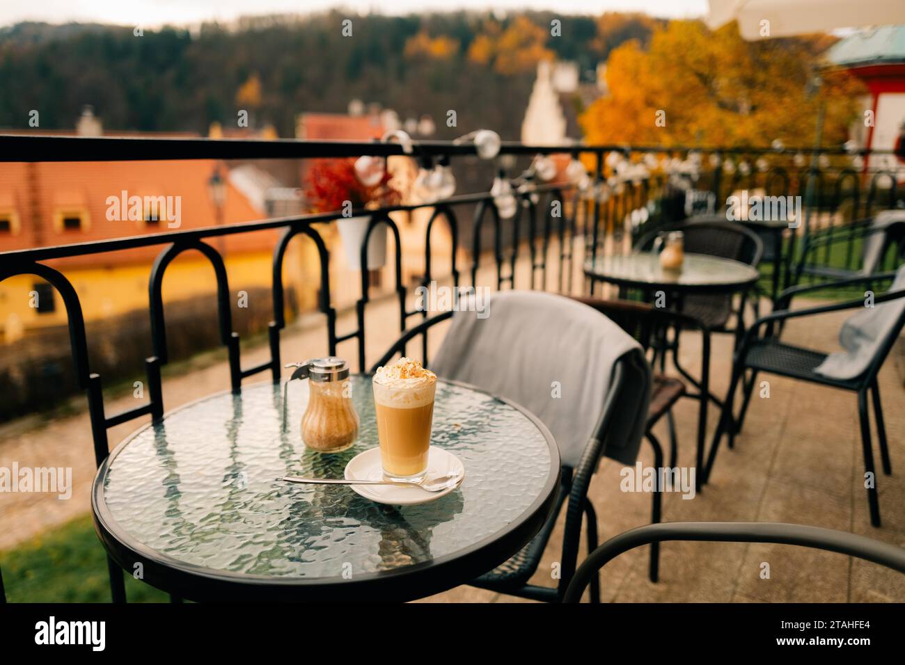 Coffee latte in an outdoor cafe in autumn in an old European town Stock Photo