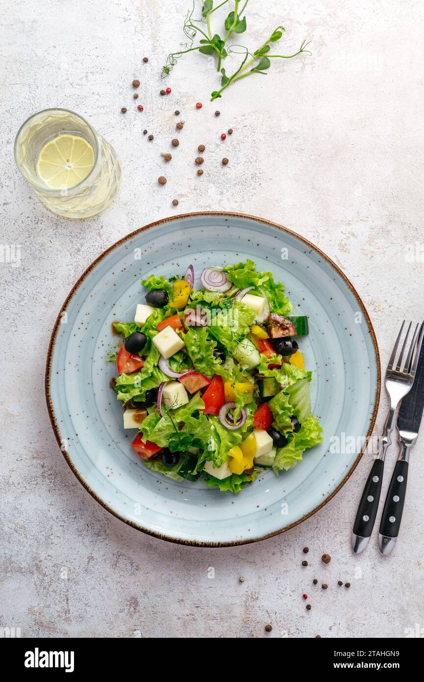 classic Greek salad in a plate on a light background Stock Photo
