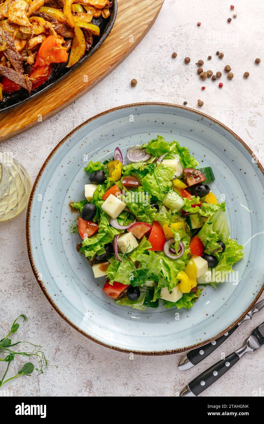 classic Greek salad in a plate on a light background Stock Photo