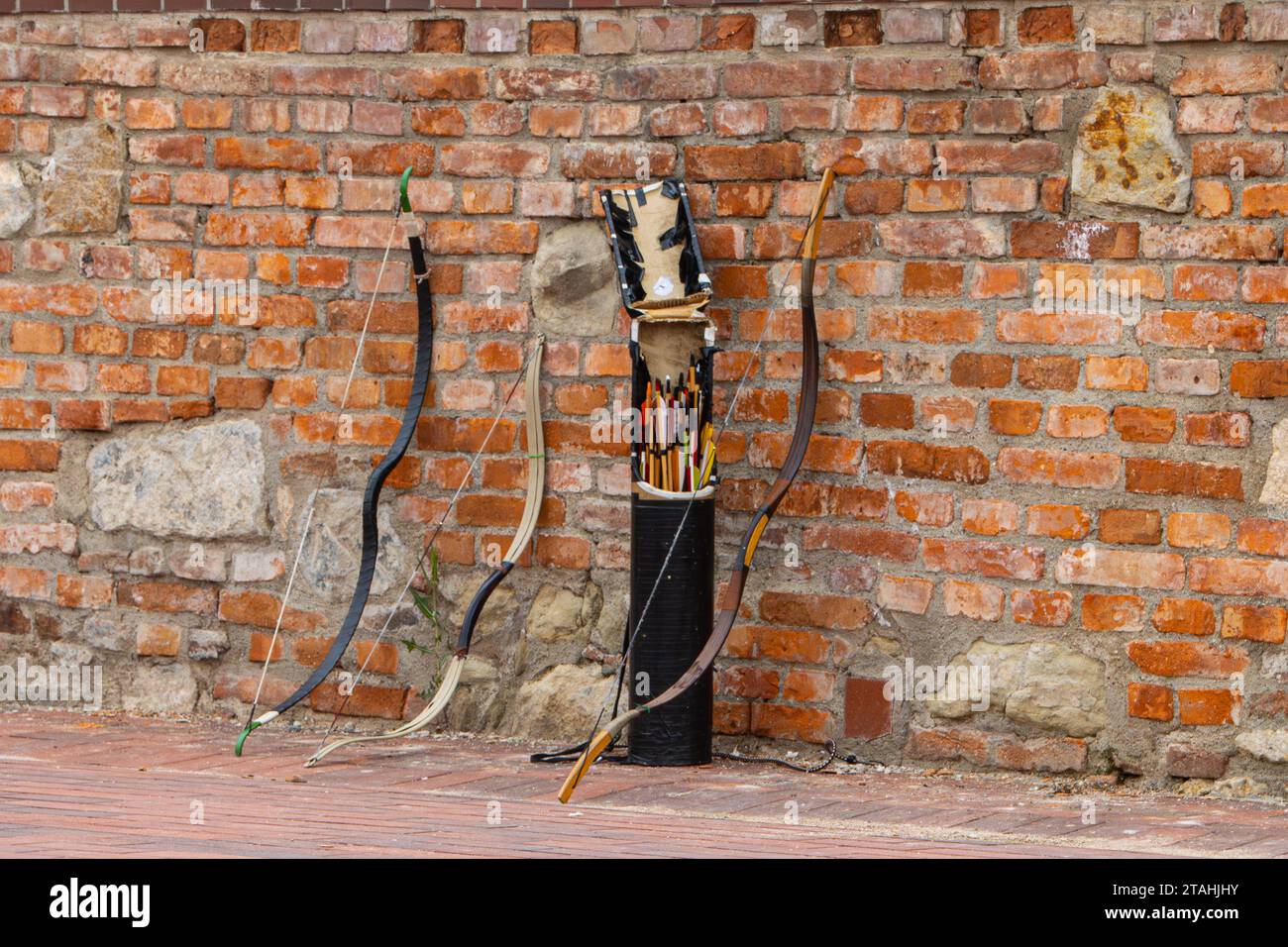 Bows and arrows leaning against a brick wall Stock Photo Alamy