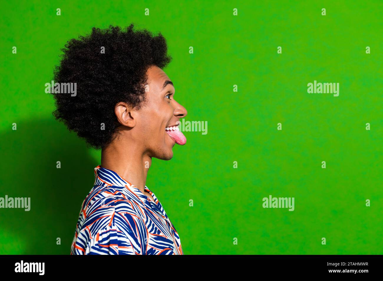 Side profile photo of funky guy tongue out fooling looking empty space