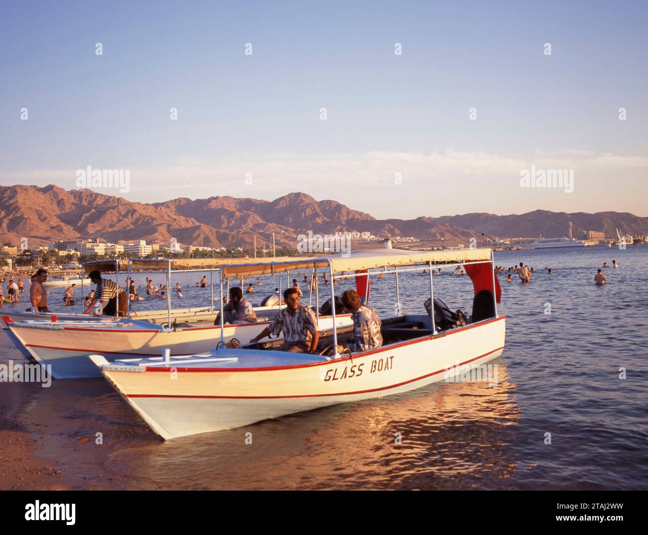 AQABA, JORDAN- MAY 061, 2018: Glass boats for rent at the beach of Aqaba in Jordan at sunset. Stock Photo