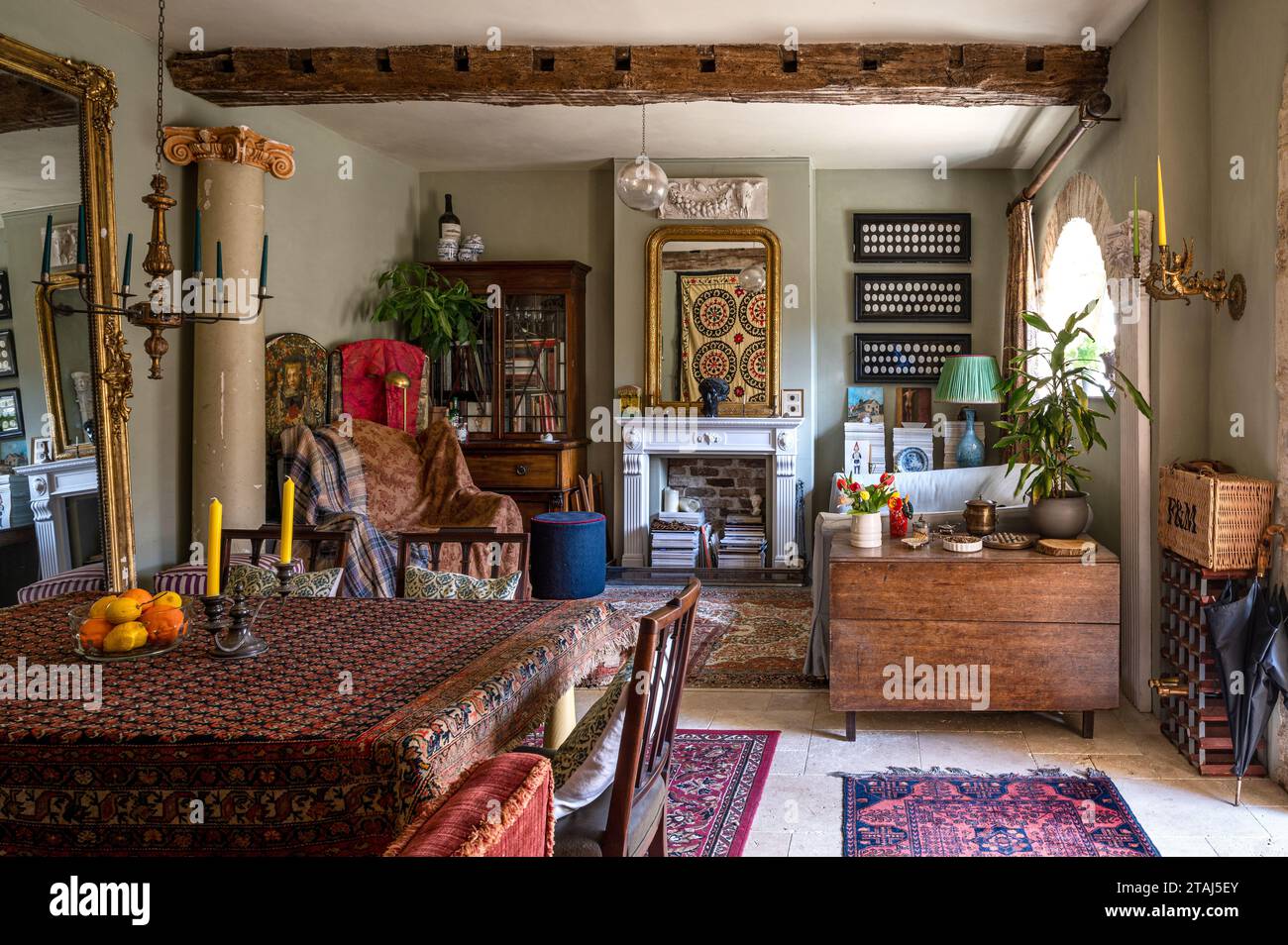 Faux fireplace with eclectic mix of antiques in Georgian barn conversion, Tetbury, Gloucestershire, UK. Stock Photo