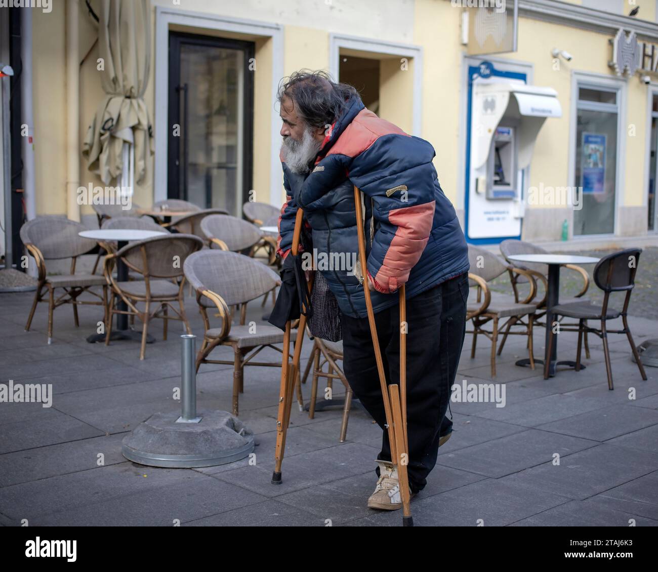 Belgrade, Serbia, Nov 19, 2023: A man walking down the street using crutches Stock Photo