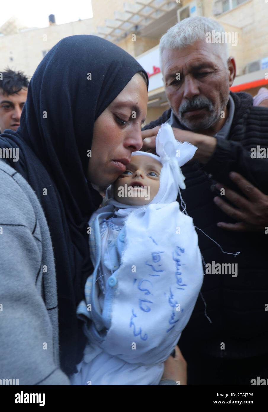 Dead body of a 5-month-old Palestinian baby named Muhammad Hani Al-Zahar, is brought to the Al-Aqsa Martyrs Hospital Dead body of a 5-month-old Palestinian baby named Muhammad Hani Al-Zahar, is brought to the Al-Aqsa Martyrs Hospital by his mother Asmahan Attia Al-Zahar and grandfather Attia Abu Amra after the Israeli airstrikes at the end of the humanitarian pause in Deir Al-Balah, Gaza on December 1, 2023. 32 Palestinians were killed within 3 hours of the end of the humanitarian pause in Gaza. Photo by Omar Ashtawy apaimages Dair El-Balah Gaza Strip Palestinian Territory 011223 Dair Balah OS Stock Photo