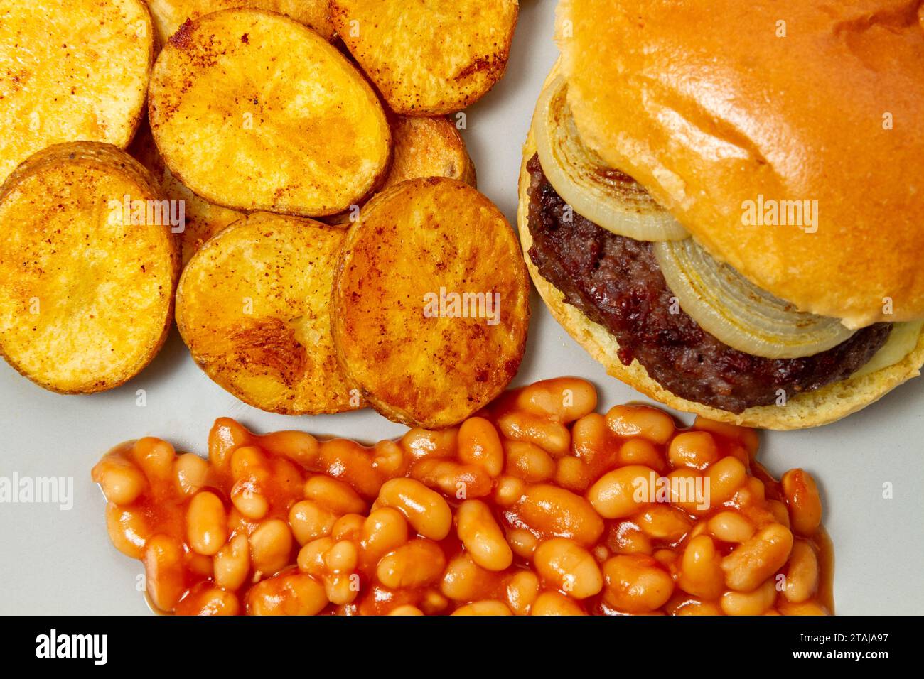 Burger saute potatoe slices and baked beans, close up Stock Photo