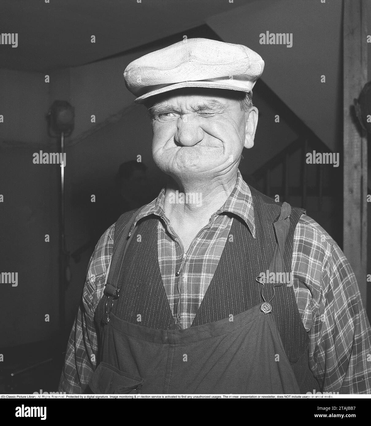 In the 1940s.  The elderly man has a white cap on his head and makes a funny face. Sweden 1947. ref AA46-3 Stock Photo