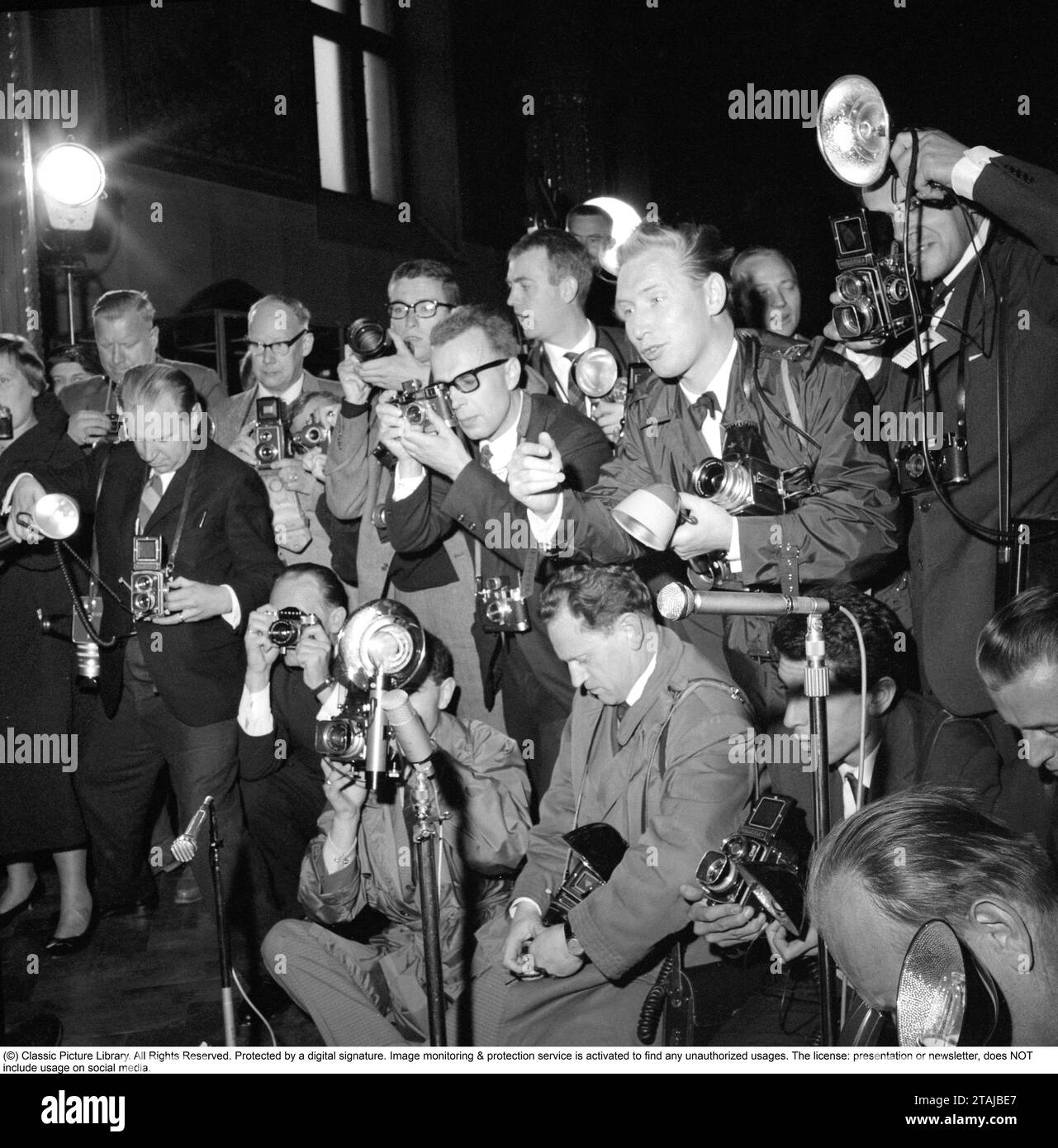 Press photographers. Media is very interested in covering the wedding  of Princess Birgitta of Sweden with prince Johann Georg of Hohenzollern-Sigmaringen in Sigmaringens church may 30 1961. The pressphotographers at the event are all trying to get good pictures of the couple. Many different cameras are visible, Rolleiflex, Hasselblad, Leica. Stock Photo