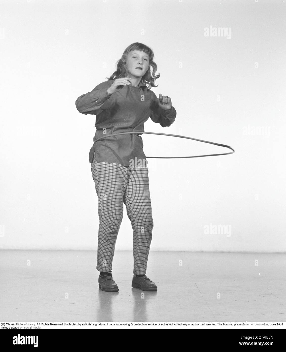 In the 1950s. A girl Hula hooping. A craze that culminated during 1958 with some 20 million hula hoop rings sold in less than four months in the USA. Sweden 1957 Stock Photo