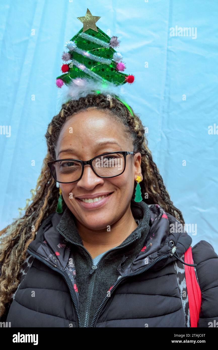 New York, New York, USA. 30th Nov, 2023. Woman wearing tree headgear at the 100th annual tree lighting on Wall St. in front of the NYSE. The NYSE hosted musical performances, refreshments and activites celebrating the Christmas Season. Hot cocoa, sounds of the season and Santa delighted the crowds with the tree lighting ceremony at the end of the evening. (Credit Image: © Milo Hess/ZUMA Press Wire) EDITORIAL USAGE ONLY! Not for Commercial USAGE! Stock Photo