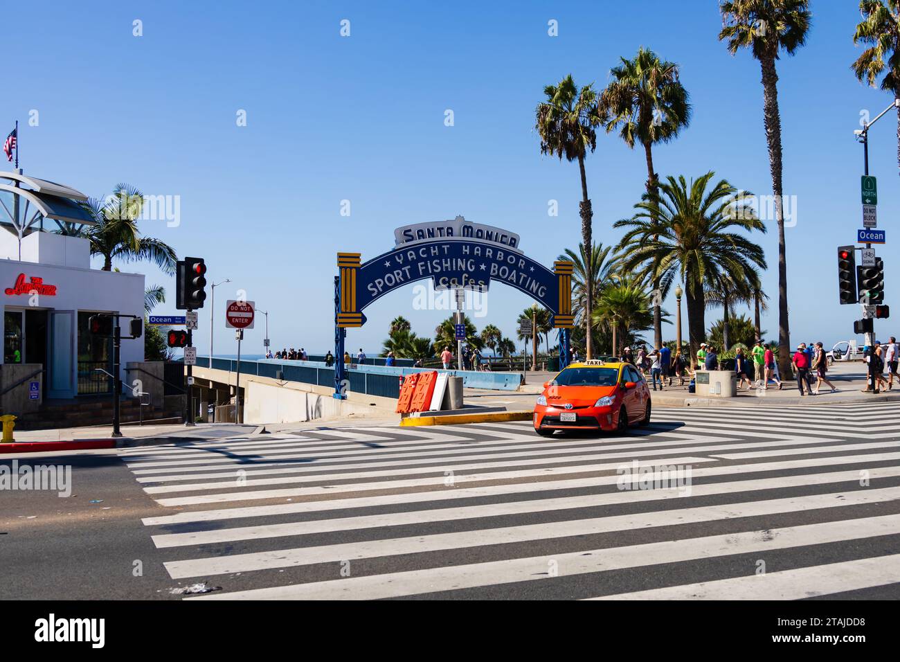 Orange and yellow, Toyota Prius taxi cab leaving Santa Monica pier onto