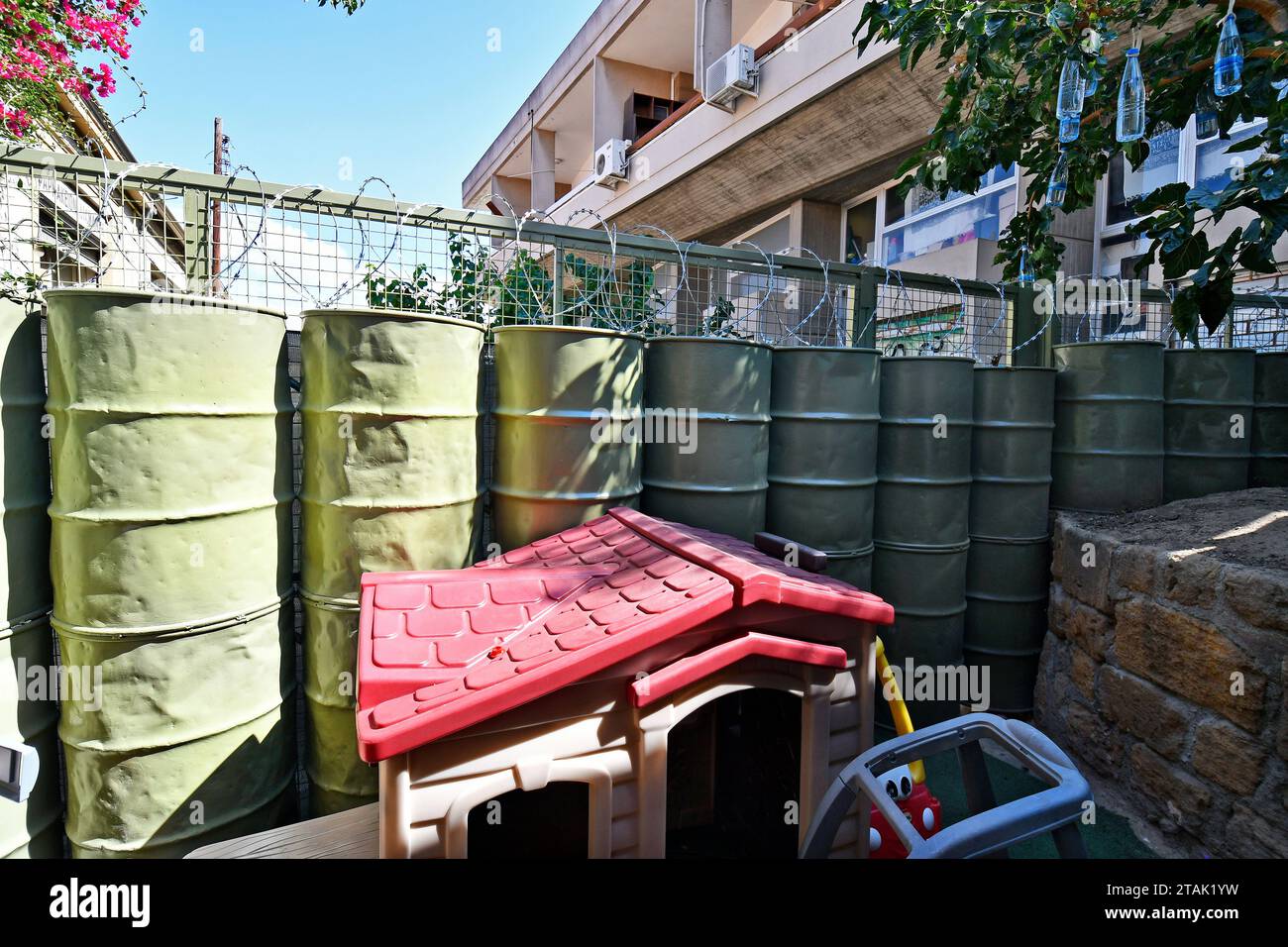 Lefkosia, Cyprus - September 30, 2023: Barrier with barbed wire right next to a playground for children, border between the Cypriot southern part and Stock Photo