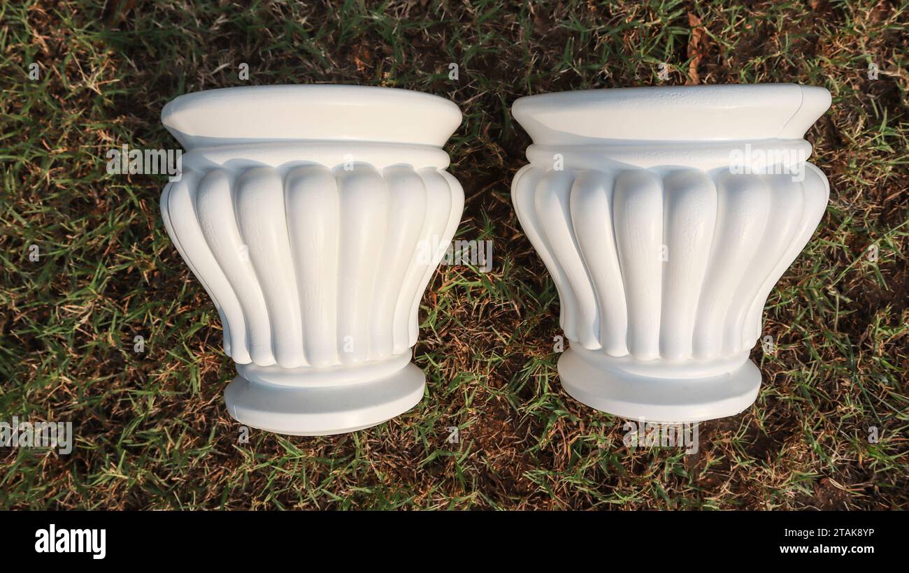 Set of Two plastic matki shaped fancy designer pot. Empty planter small size with curvy shape. Plastic pot container on green grass in house garden Stock Photo
