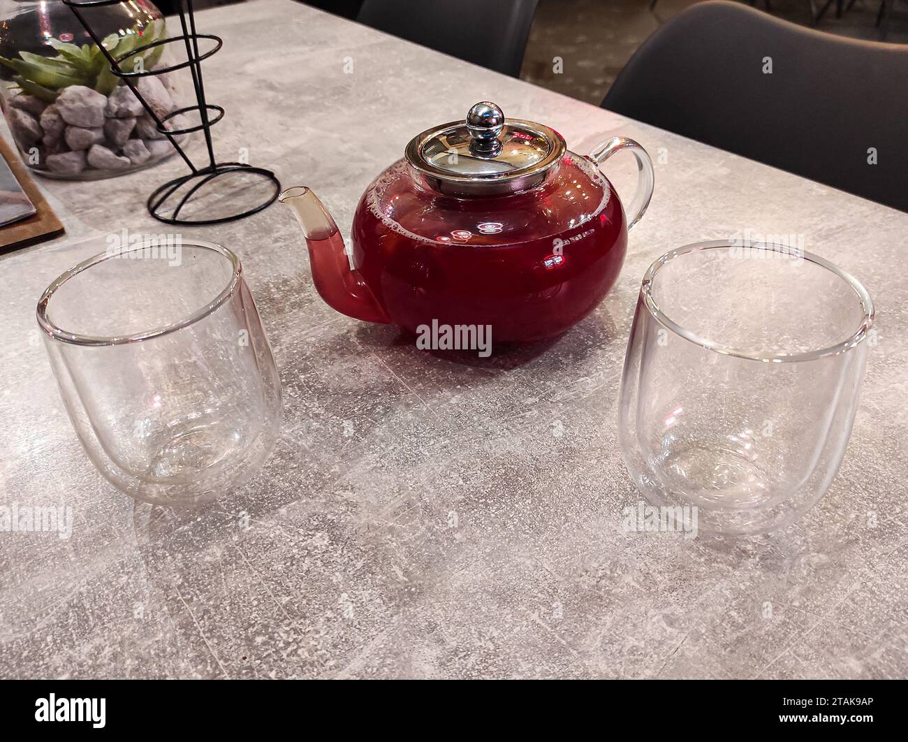 https://c8.alamy.com/comp/2TAK9AP/a-glass-kettle-with-fruit-tea-in-it-and-two-regular-glasses-beside-it-2TAK9AP.jpg