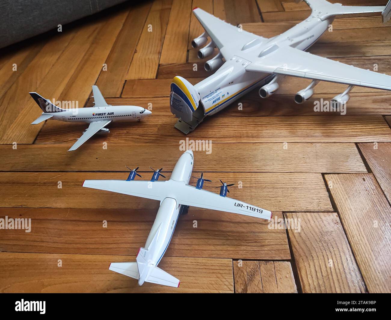 Antonov Airlines An-225, Motor Sich Antonov An-12, and First Air Boeing 737-200 aircraft models on a floor, all in 1:200 scale Stock Photo